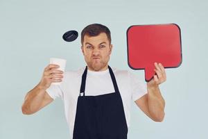 Angry and holding drink in hand. Man standing in the studio with empty signs for the text photo