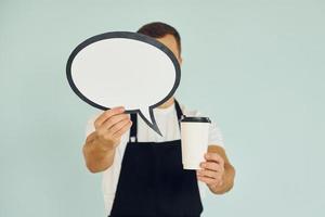 Holding drink in hand. Man standing in the studio with empty signs for the text photo