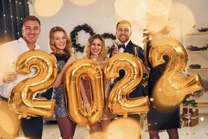 2022 year. Group of people have a new year party indoors together photo