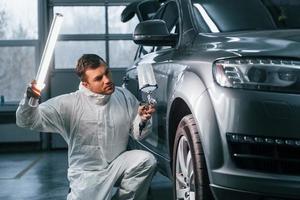 trabajador profesional. el hombre de uniforme está en el servicio de automóviles foto