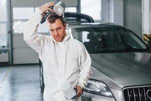 Job is done. Man in uniform is working in the auto service photo