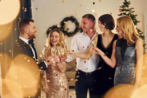 tiempo de Navidad. grupo de personas tienen una fiesta de año nuevo en el interior juntos foto