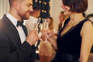 Cheerful couple. Group of people have a new year party indoors together photo