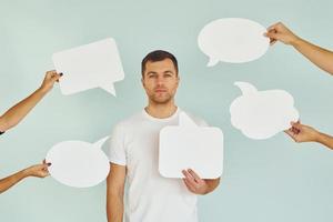 muchos de los diferentes pensamientos. hombre de pie en el estudio con carteles vacíos para el texto foto