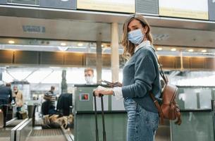 Receiving help from worker. Young female tourist is in the airport at daytime photo