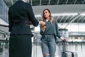 With documents. Young female tourist is in the airport at daytime photo