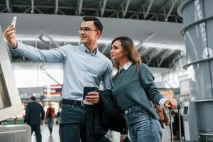 haciendo selfie pareja joven está en el aeropuerto juntos foto