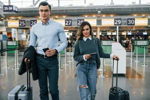 caminando hacia adelante pareja joven está en el aeropuerto juntos foto