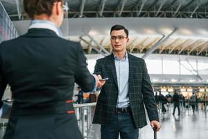 Passing through. Young businessman in formal clothes is in the airport at daytime photo