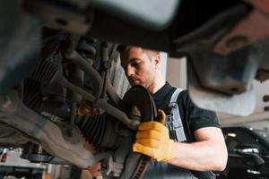 servicio profesional. el hombre de uniforme está trabajando en el servicio de automóviles foto