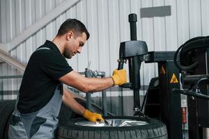 Strong hands. Man in uniform is working in the auto service photo