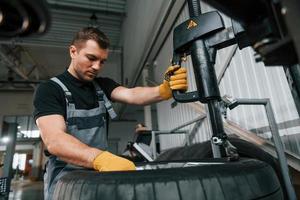 Strong hands. Man in uniform is working in the auto service photo