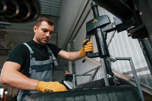 Strong hands. Man in uniform is working in the auto service photo