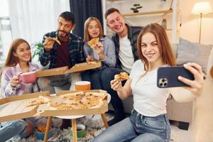 Making selfie photo. Group of friends have party indoors together photo