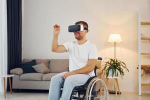 In VR glasses. Disabled man in wheelchair is at home photo