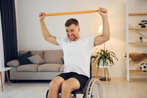 estirando las manos. hombre discapacitado en silla de ruedas está en casa foto