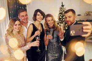 emociones positivas. grupo de personas tienen una fiesta de año nuevo en el interior juntos foto