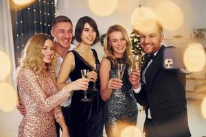 Making selfie. Group of people have a new year party indoors together photo