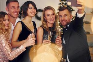 Making selfie. Group of people have a new year party indoors together photo