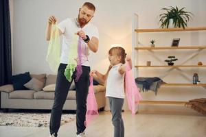 divirtiéndose. padre con su pequeña hija está en casa juntos foto