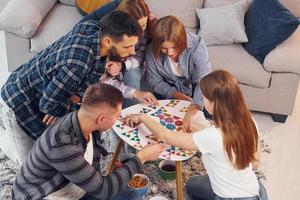 Playing puzzle game. Group of friends have party indoors together photo