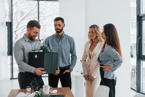 Holding package in hands. Group of business people that working on the project in the office photo