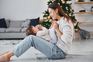 ánimo de vacaciones. madre con su pequeña hija está adentro en casa juntos foto