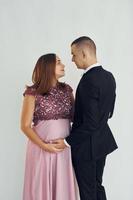 Couple in formal clothes standing in the studio with white background photo