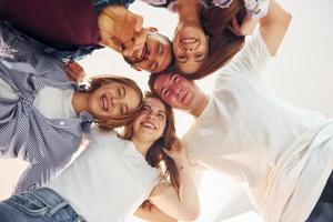 Looking down. Group of friends standing together photo