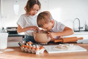 Preparing Christmas cookies. Little boy and girl on the kitchen photo