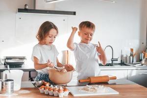 Preparing Christmas cookies. Little boy and girl on the kitchen photo