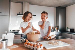 Brother and sister. Little boy and girl preparing Christmas cookies on the kitchen photo