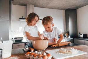 Brother and sister. Little boy and girl preparing Christmas cookies on the kitchen photo