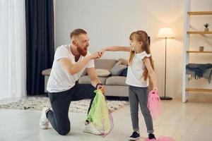 Having fun. Father with his little daughter is at home together photo