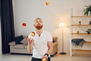 A man in casual clothes throws balls at home photo