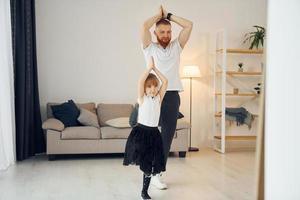 enseñando a bailar. padre con su pequeña hija está en casa juntos foto