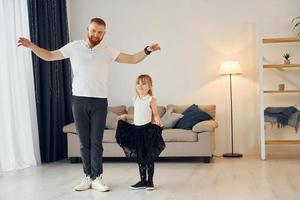 Yoga poses. Father with his little daughter is at home together photo