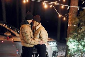 Looking at each other. Couple standing in the forest and celebrating New year photo