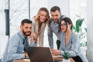 conexión a Internet mediante el uso de una computadora portátil. grupo de empresarios que trabajan en el proyecto en la oficina foto