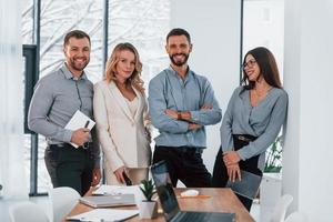 de pie juntos grupo de empresarios que trabajan en el proyecto en la oficina foto