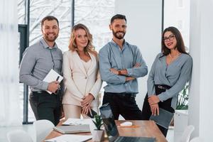 de pie y posando. grupo de empresarios que trabajan en el proyecto en la oficina foto