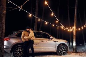 Love and hugs. Couple standing in the forest and celebrating New year photo