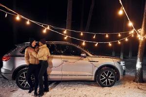 estado de ánimo de vacaciones y decoraciones. pareja de pie en el bosque y celebrando el año nuevo foto