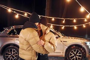 estado de ánimo de vacaciones y decoraciones. pareja de pie en el bosque y celebrando el año nuevo foto