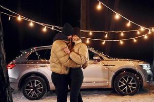 estado de ánimo de vacaciones y decoraciones. pareja de pie en el bosque y celebrando el año nuevo foto