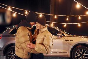 Holiday mood and decorations. Couple standing in the forest and celebrating New year photo