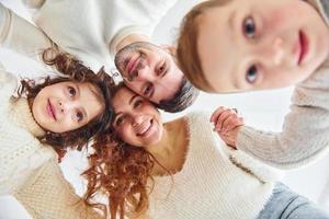 sonriendo y divirtiéndose. vista desde abajo. familia feliz mirando hacia abajo foto