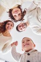 Smiling and having fun. View from below. Happy family looking down photo