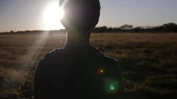 Young Man, Teenage Boy Stands In Field Watching The Sunset video