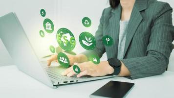 esg medio ambiente gobernanza social concepto de negocio de inversión. las mujeres usan una computadora para analizar esg, rodeadas de iconos de esg. cerca de la pantalla de la computadora en el concepto de estrategia de inversión empresarial. foto